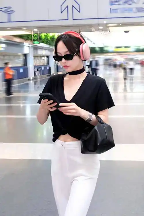 张嘉倪现身机场,身穿黑色裸上衣和白色裤子,简单,时尚,还显得更高!