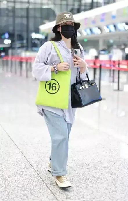 阚清子里面穿条纹t恤,外面搭配大码衬衣,下身穿复古风牛仔裤,脚踩高帮