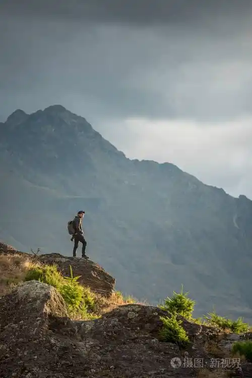 在皇后镇看风景的年轻男性摄影师