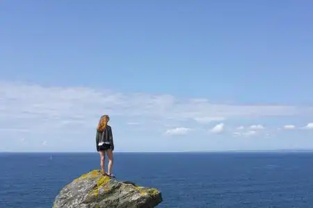 面朝大海享受海景的山顶上的女孩照片