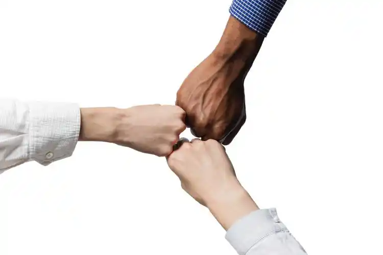 三个人的手把他们的拳头放在一起作为团队合作团队加油团结拳头团结