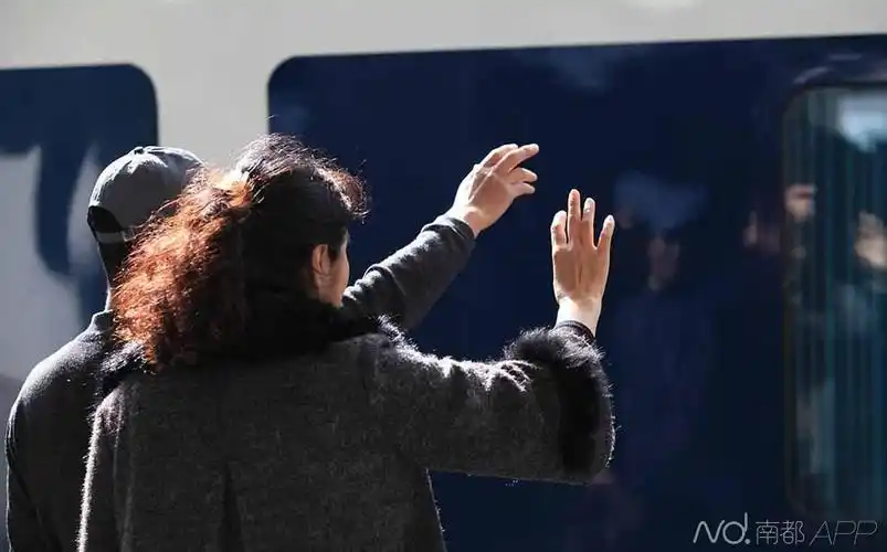 下午,深圳火车站开往上海的列车,两位市民与车上的亲人挥手再见.