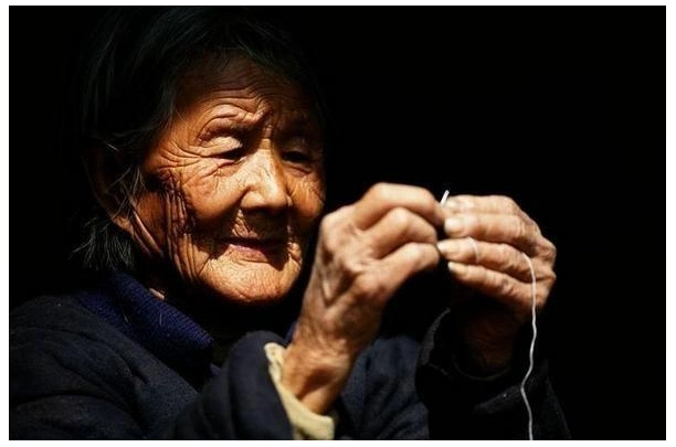 那时村里没通电,儿子每晚在油灯下书声朗朗,写写画画,母亲拿着针线