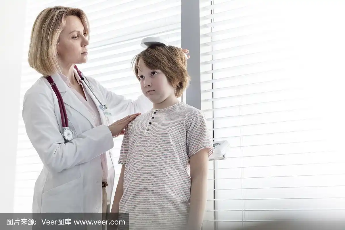 儿科医生在检查室检查男孩的身高