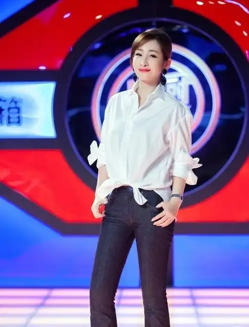 41岁秦海璐走机场,衬衫搭配九分裤洒脱干练,低绑马尾更显好气质