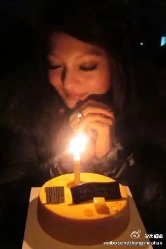 一个美女低头许愿面前有一个蛋糕 求图片.