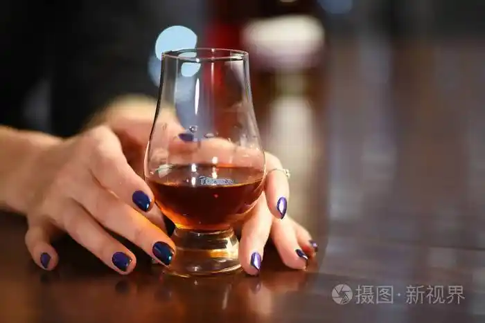 女人手拿着一杯威士忌