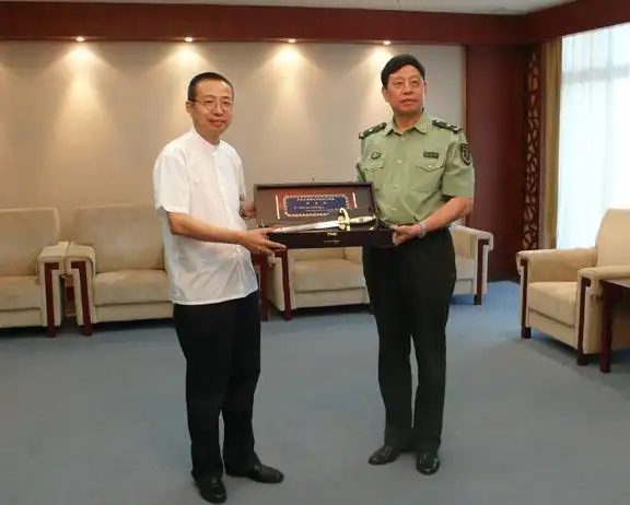 驻澳门部队司令员王玉仁向      潘鲁生院长赠送礼品