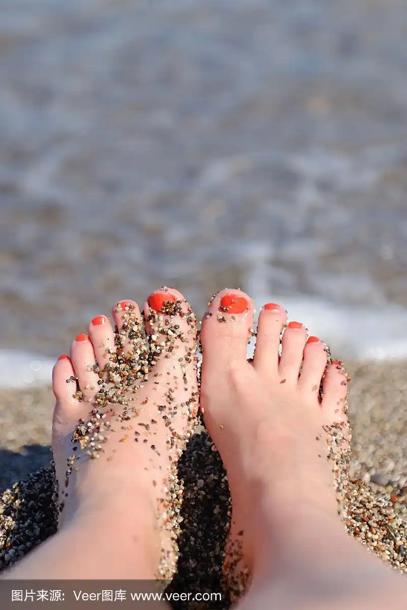 女人的脚近距离女孩放松在海滩上