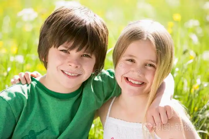 两个小孩手挽手坐在户外