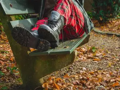 疯了男人躺在公园长椅上的男人,特写鞋靴子和裤子疯了照片
