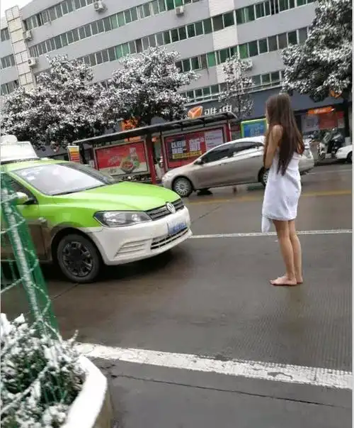 1月4日,大雪过后的汉中街头惊现一裹着浴巾的赤脚女子在寒风中瑟瑟