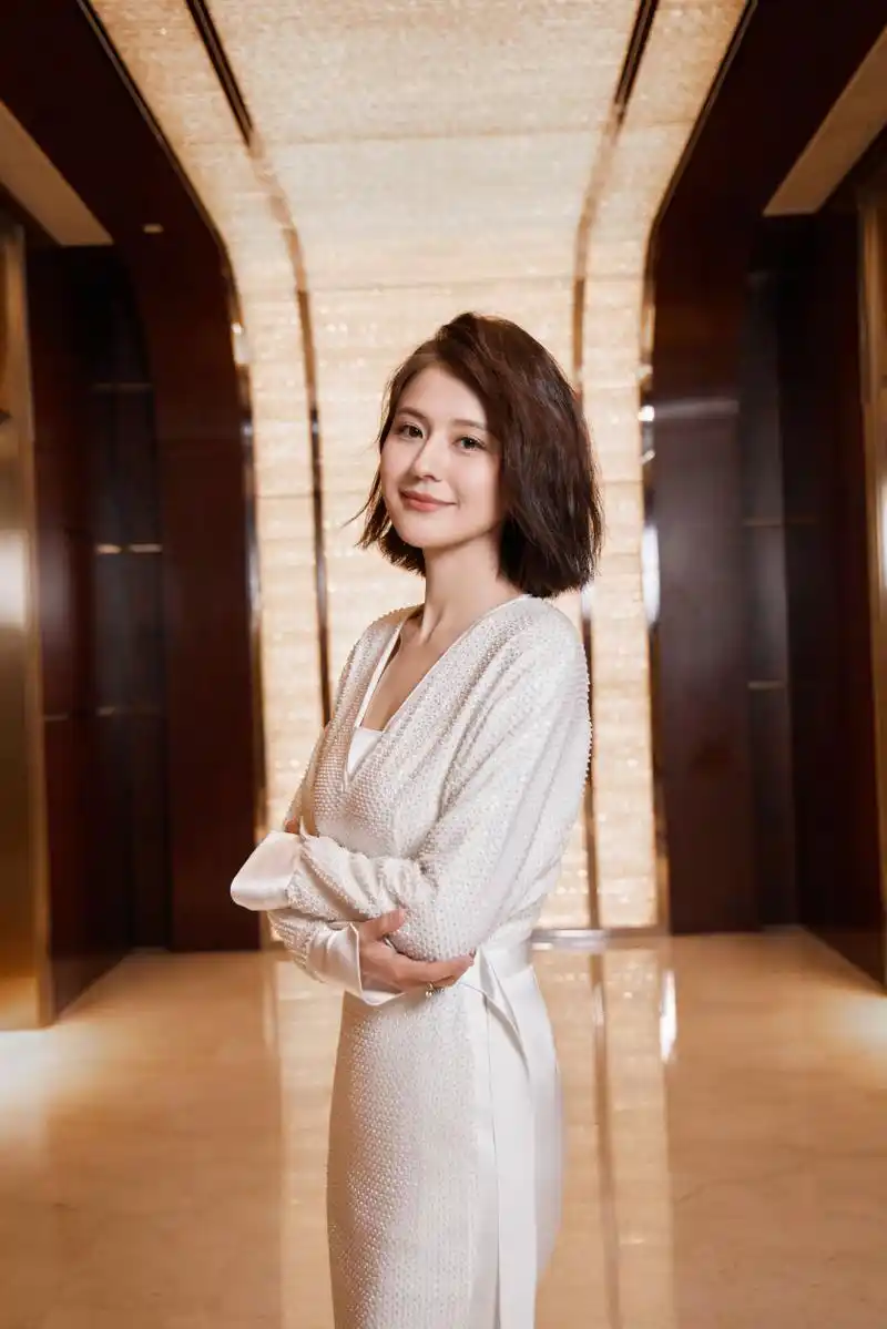 许久未露面的 热依扎,亮相上海时装周,棕色的微卷短发,梳成四六分