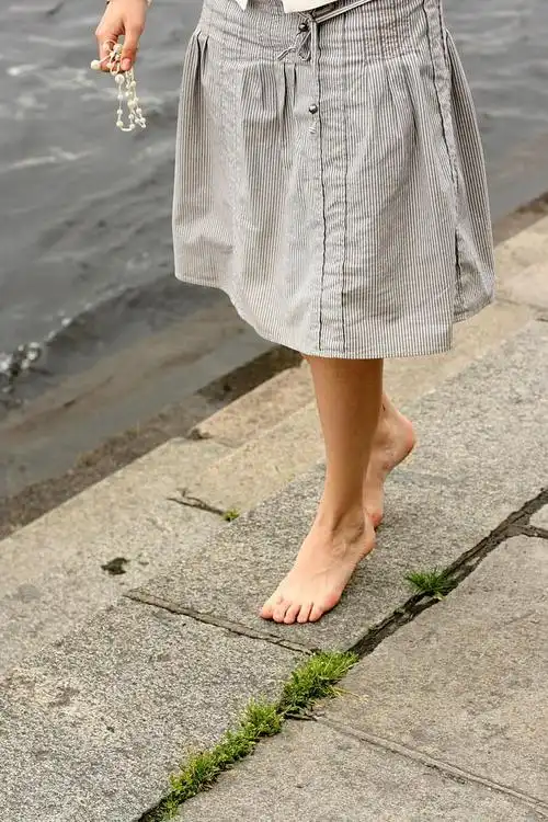 女子赤脚,踢掉鞋子,感觉你裸脚下的土地.