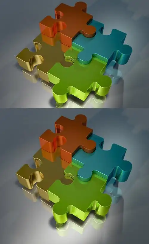 四个不同颜色的三维立体拼图拼接在一起放在光滑的银白色的水平桌面上