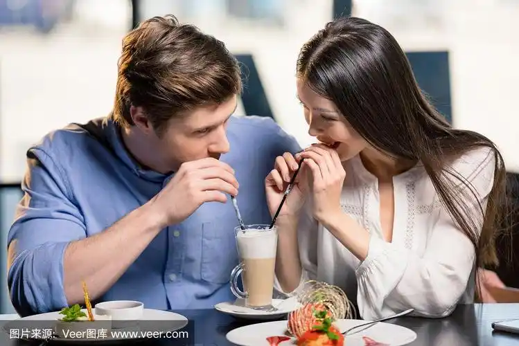 美丽幸福的年轻夫妇在餐厅浪漫的约会相爱