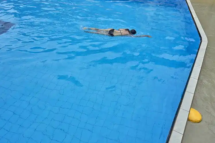 一个下雨天跳进游泳池的女人