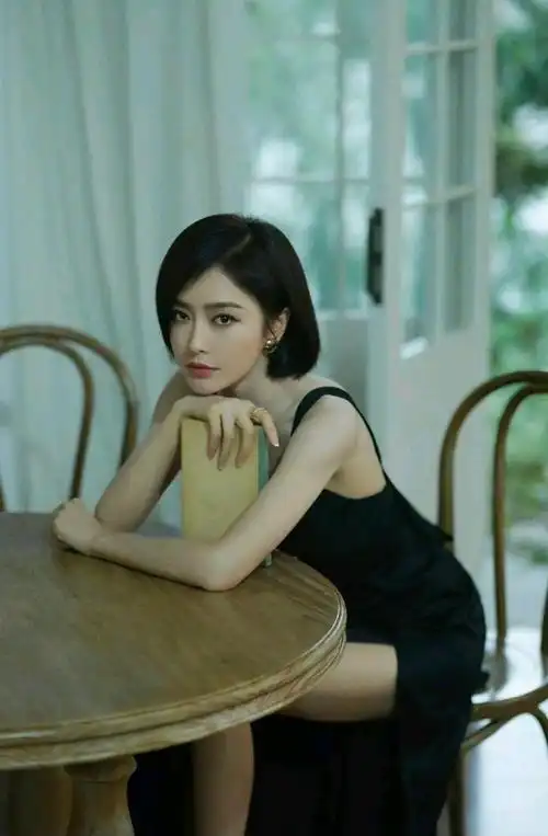 43岁的秦岚剪的一头短发,化着淡妆,身穿白色上衣搭配牛仔短裙,露出