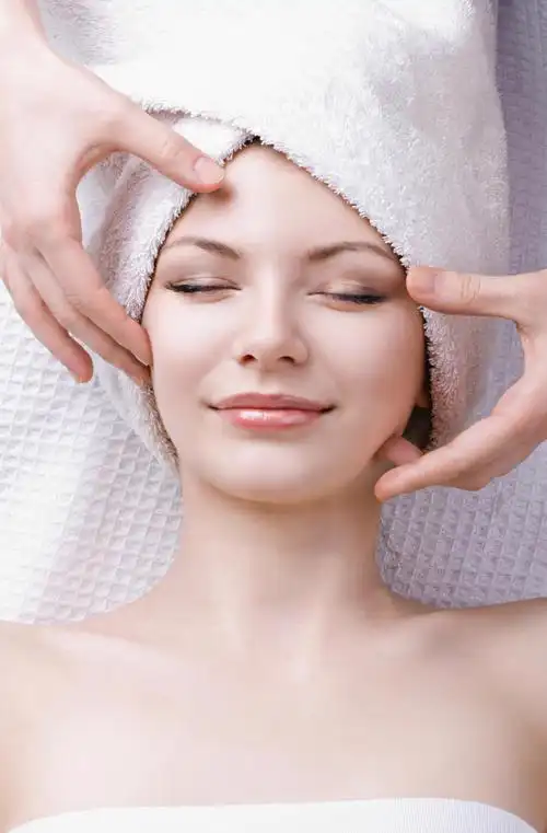 美丽的女人接受面部按摩面部清洁脸部面部按摩