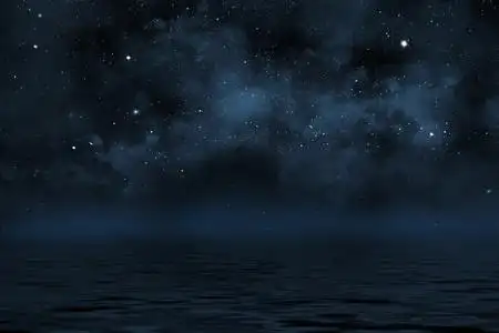 夜空背景有星星和星云,在水面上有波浪照片