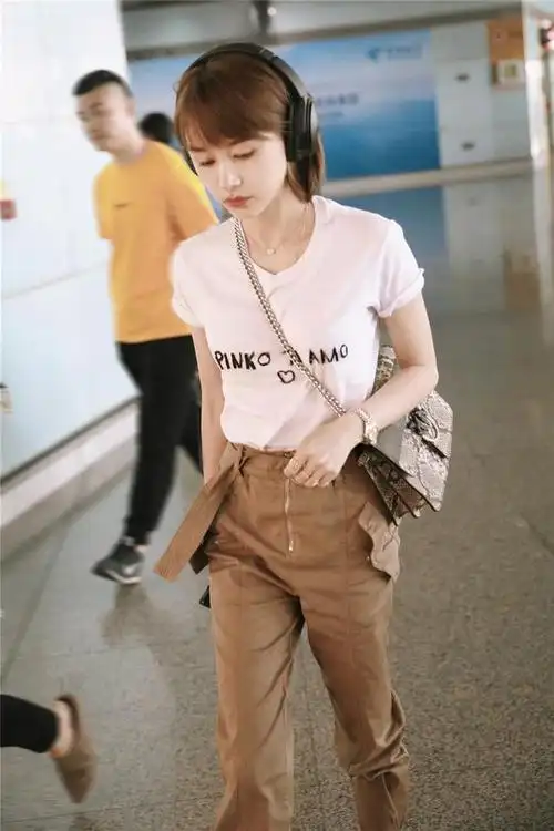 王子文脚下搭配纯白运动鞋,整体服装色彩运用从简而精炼.斜挎金属