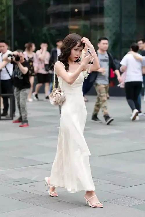 美女高挑的身姿 搭配一双白色的高跟凉鞋,增添她的成熟魅力