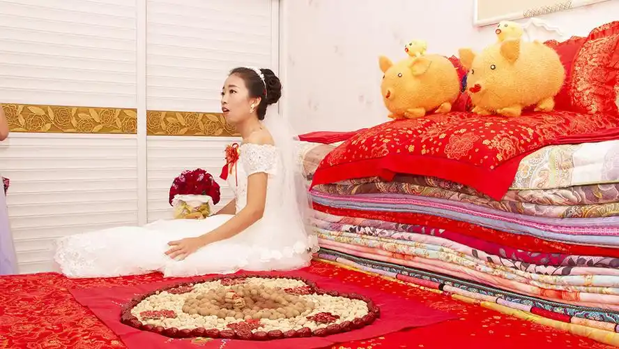 作品描述: 一切程序结束以后,新娘子坐到了摆着桂圆,花生,红枣的婚