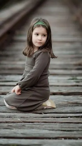 可爱的小女孩坐在铁路上,孩子,回头看