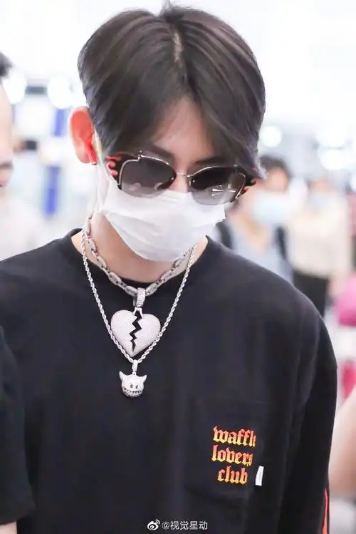 他留着中分发型后脑处的头发染成了黄色个性十足,穿火焰卫衣戴"心碎"