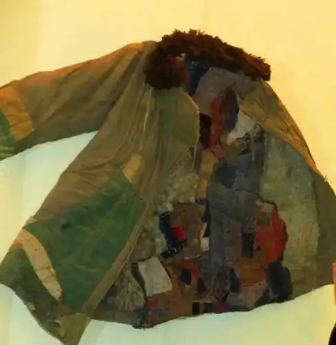 "这件缝满了补丁的军大衣就是单层衣领,只有两个口袋,不知穿了多少年