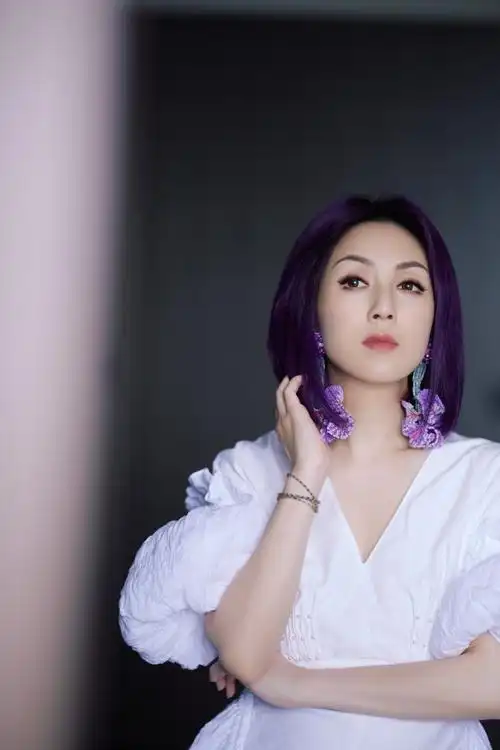 在本期节目中,杨千嬅身穿白色泡泡裙搭配紫色耳环,一身穿搭优雅大方又