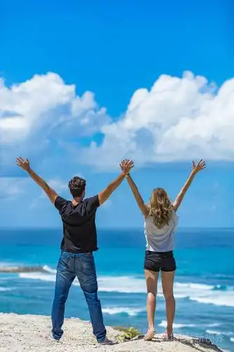 在大海/海洋中享受双臂张开的情侣