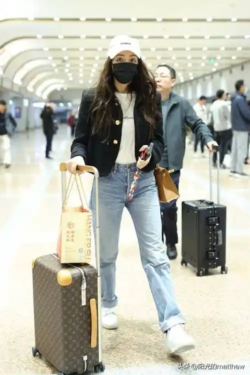 麦迪娜现身北京机场黑色外套搭配牛仔裤简约利落
