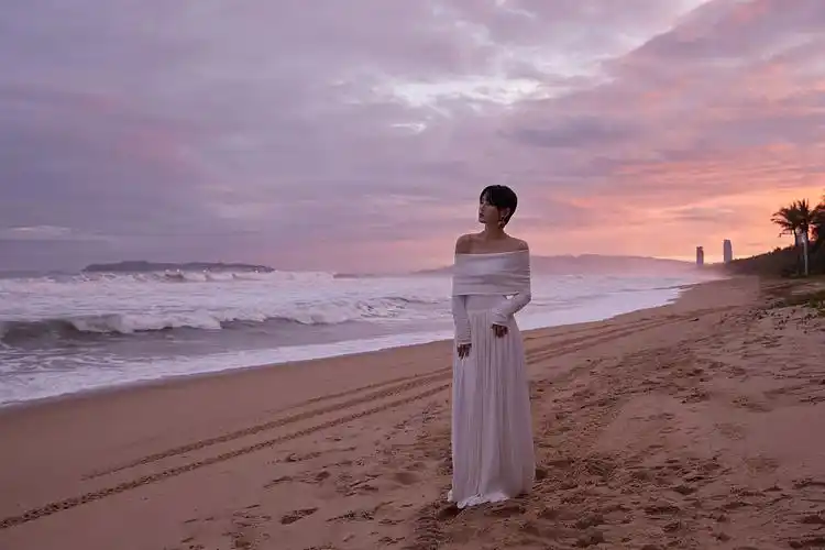 周笔畅海滩落日大片梦幻浪漫 一字肩白裙搭蓝宝石耳饰尽显高雅