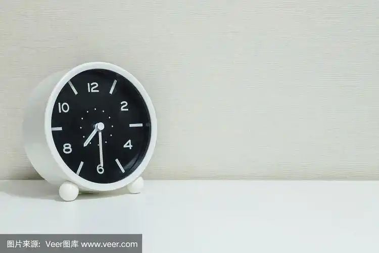 特写黑白闹钟装饰显示显示七点半或早上七点半白色木桌和奶油色壁纸