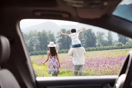在汽车外面郊游的一家三口