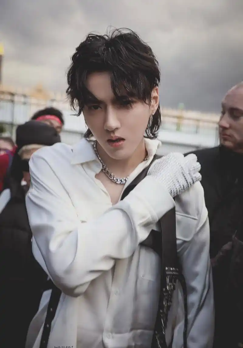 在路透中,吴亦凡在黑色的大棉衣中,穿了一件白色衬衫,加上微卷发,明眸