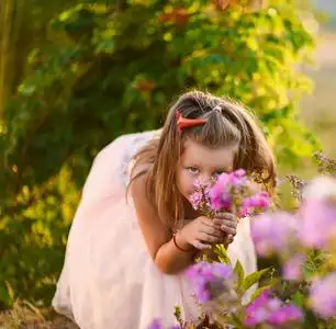 短裙作为芭蕾舞演员在阳光明媚的日子快乐童年对开花的夏天的背景照片