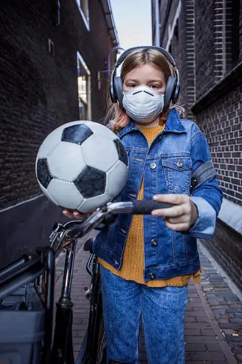 在户外戴口罩的年轻女学生图片下载