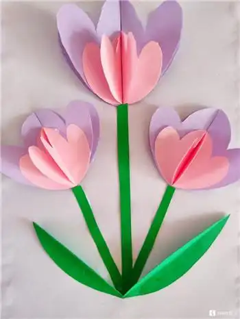 再准备绿色卡纸,把它对折,用剪刀剪出叶子的形状,把它粘贴到花茎的