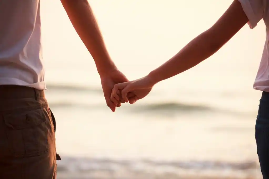 年轻夫妇手牵着手,情侣手牵手的特写镜头