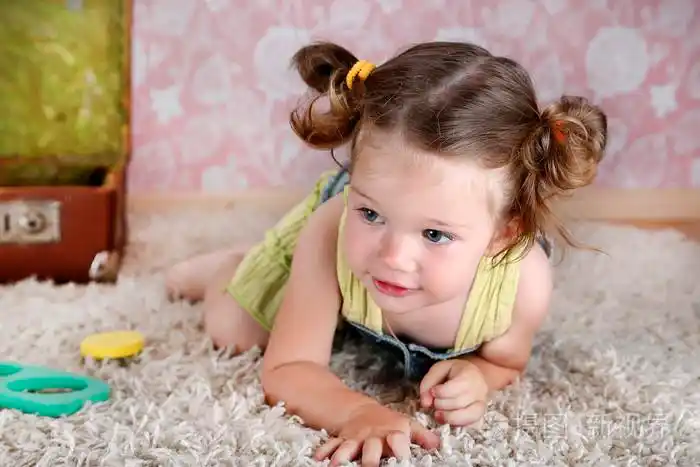 漂亮的小女孩在地毯上