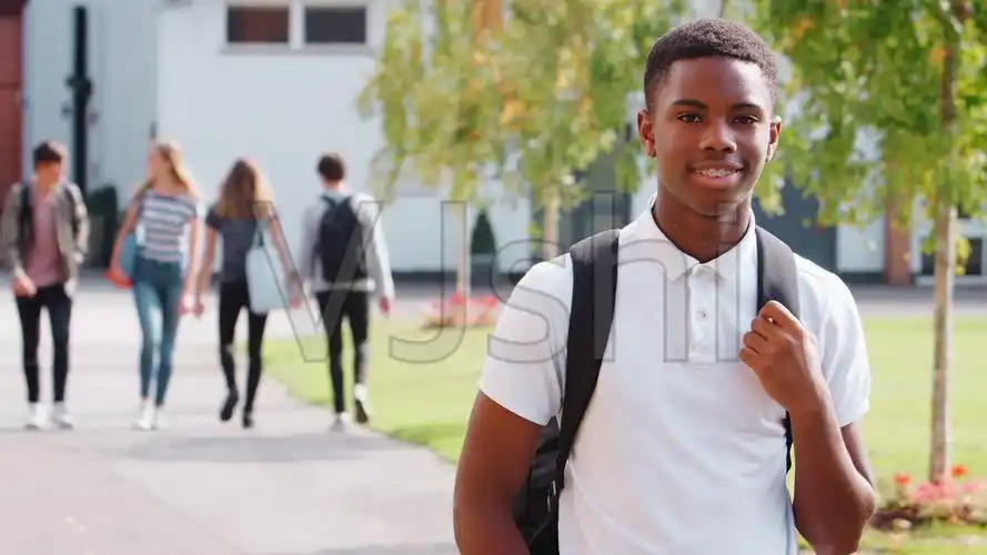 十几岁的男学生在大学校园里散步的照片