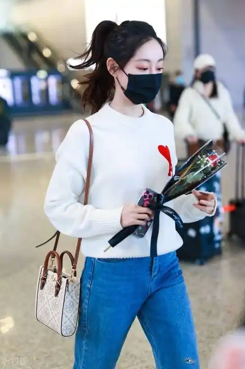 祝绪丹白色毛衣搭牛仔裤现身机场手拿鲜花心情好