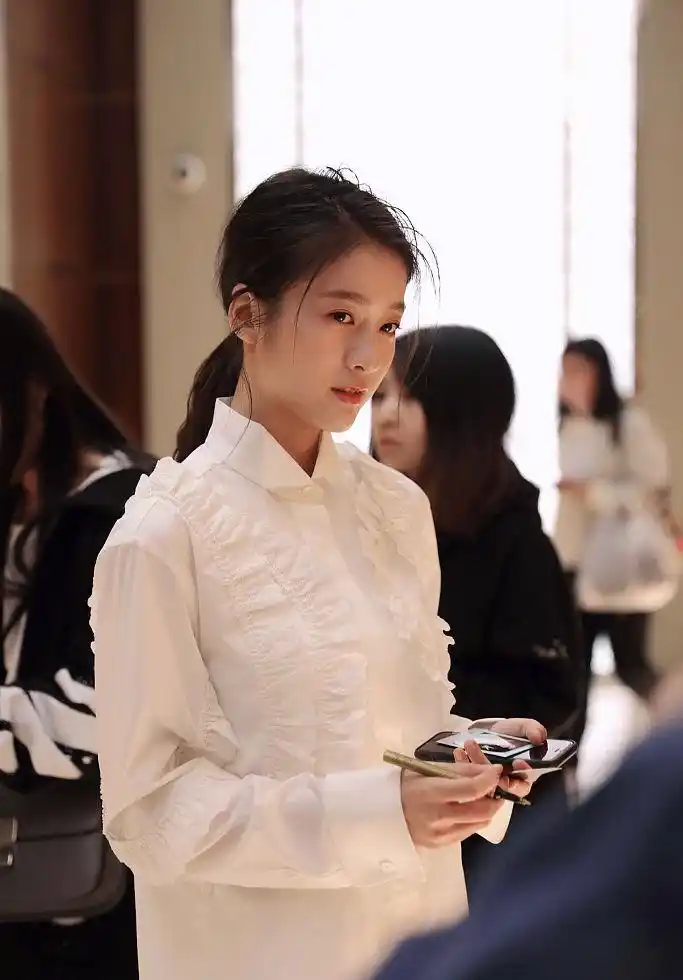 张雪迎穿白衬衫笑容甜美气质清纯 低头玩手机侧颜精致
