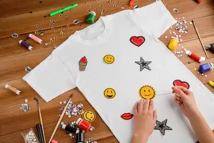 在t恤上缝补丁的女孩女孩用贴片和水钻在t恤上画星星的女孩女孩定制她