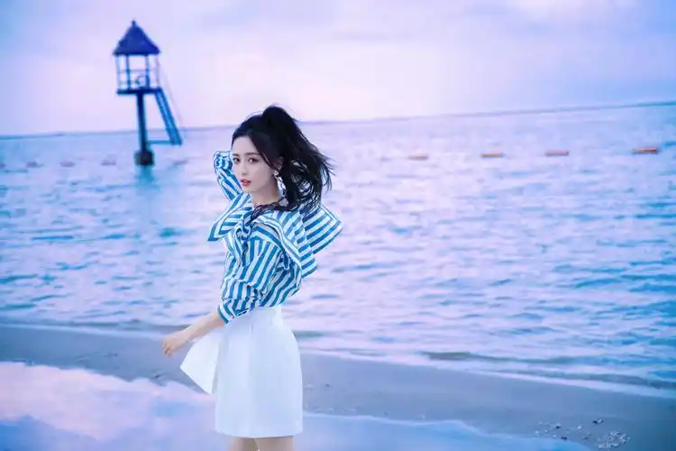 佟丽娅晒海边漫步照青春活力 穿蓝白套装优雅明媚