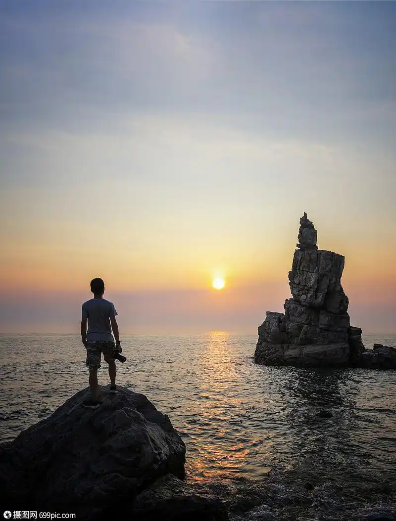 海边迎接朝阳的男性背影