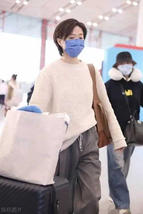 街拍:万茜米白色针织衫 灰色老爹西裤 麂皮单肩包轻松随性_北京_机场