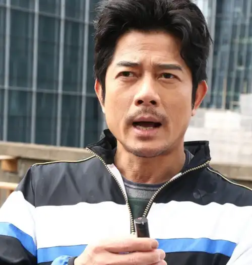 穿着黑白毛皮衣服的郭富城留着胡子,头发蓬乱,形状有点奇怪.